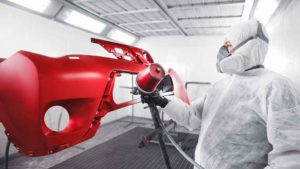 Collision Repair Services - Painter Spraying bumper in booth