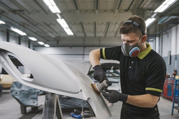 Certified Collision Repair tech sanding bumper